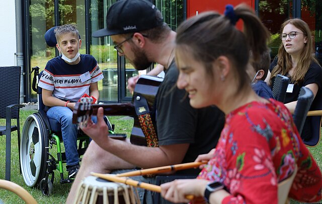 Fotografie von behinderten Kindern die gemeinsam mit Menschen ohne Behinderung musizieren. 